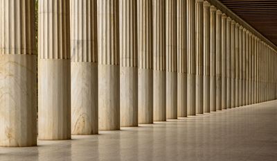 A row of tall, fluted marble columns stretches into the distance, creating a sense of depth.