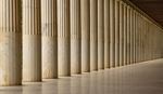A row of tall, fluted marble columns stretches into the distance, creating a sense of depth.
