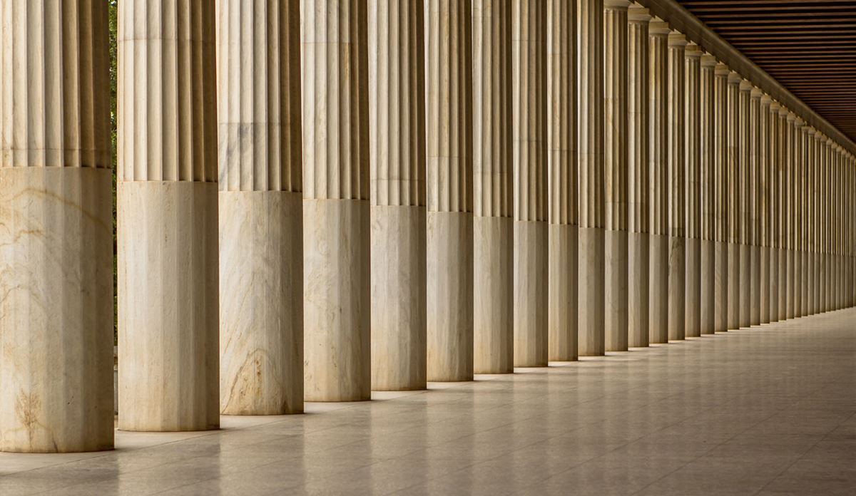 A row of tall, fluted marble columns stretches into the distance, creating a sense of depth.