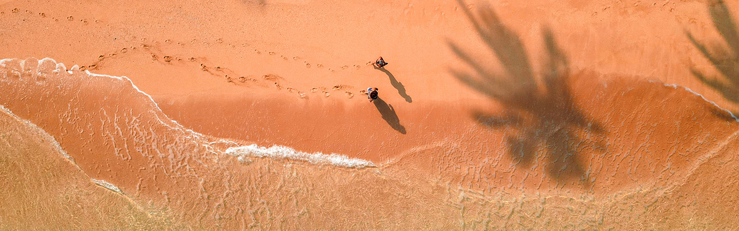 Two people walking around sea