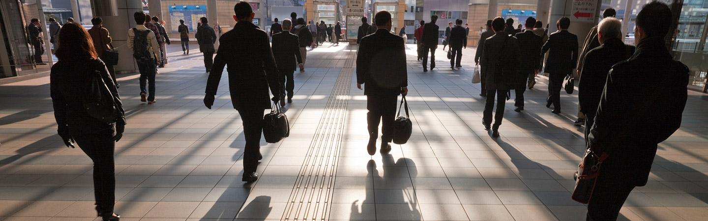 People in business attire walking away and casting shadows