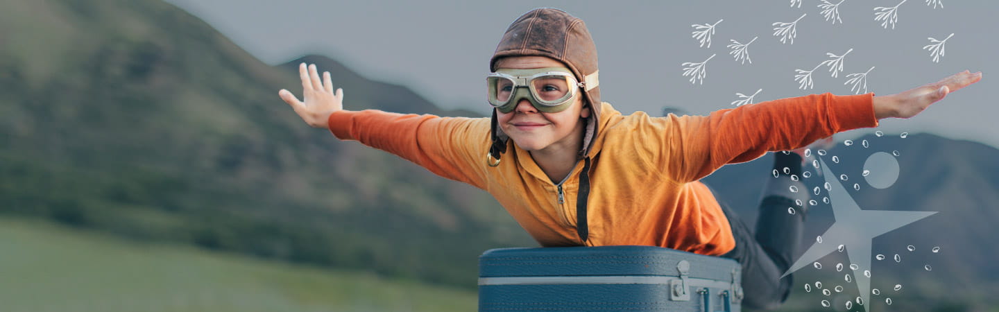 Child in orange shirt with arms in flying position
