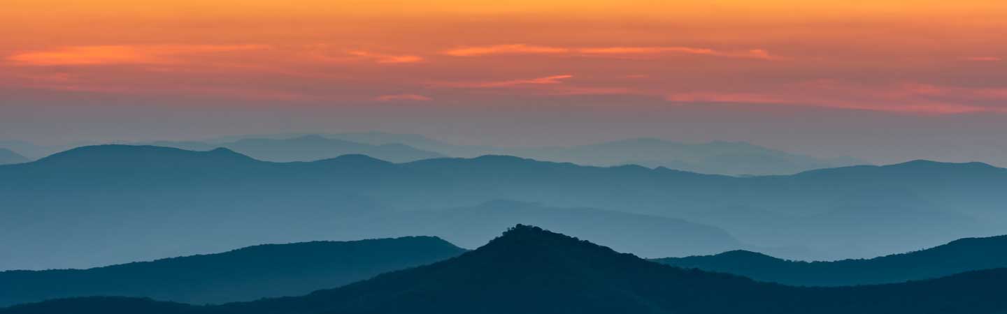 A misty mountain range at sunset