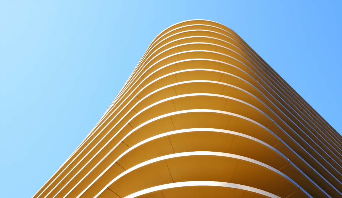 Modern curved yellow skyscraper viewed from below