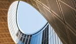 View from inside a building, looking up at a clear blue sky framed by the structure's edges