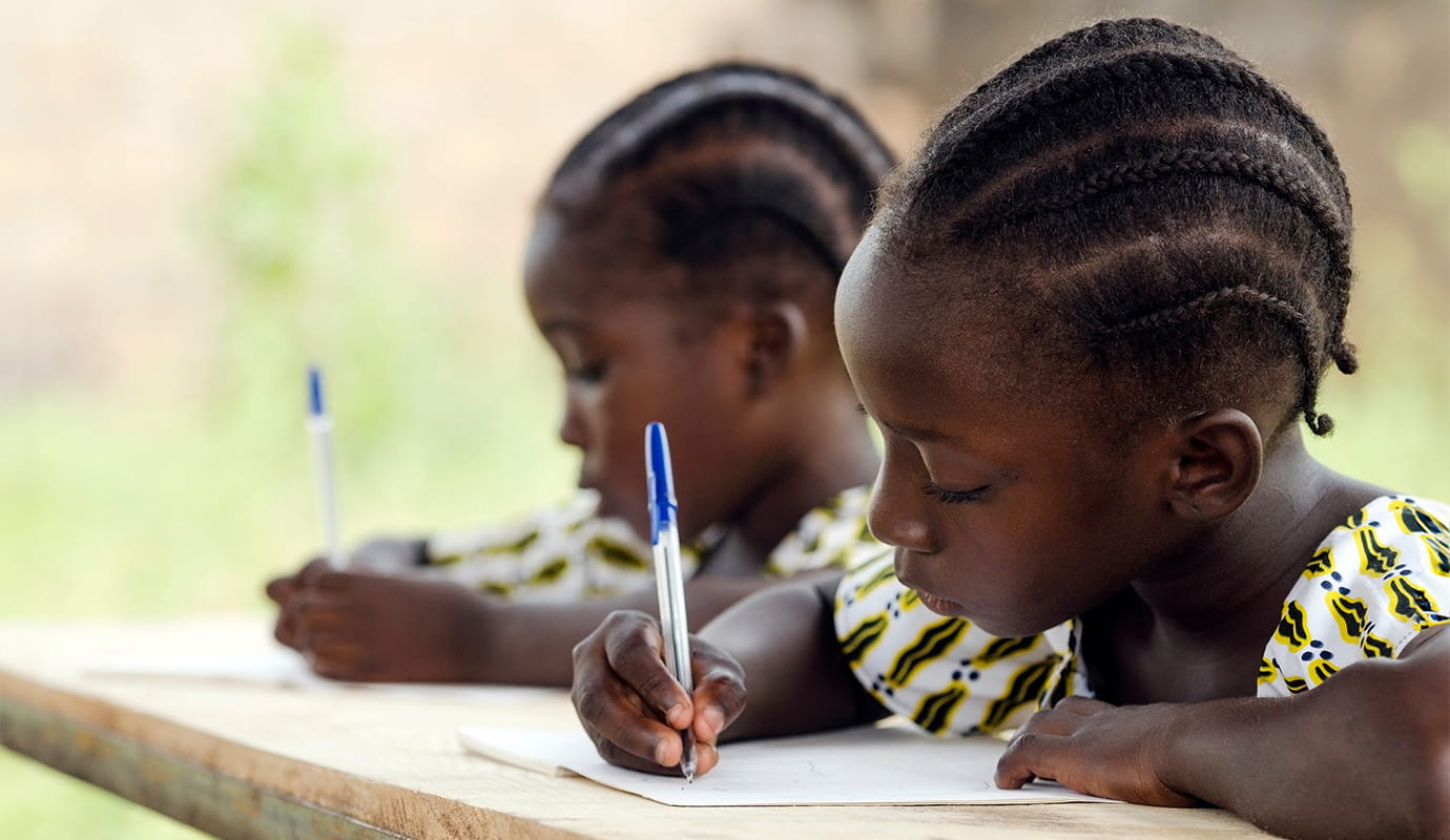 Indian children smiling and sitting on a floor
