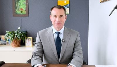A man in a grey suit in an office setting