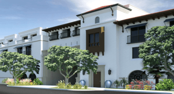 Modern Mediterranean-style building with white stucco walls, red-tiled roof, and decorative arches. Lush trees and colorful flowers in the foreground.